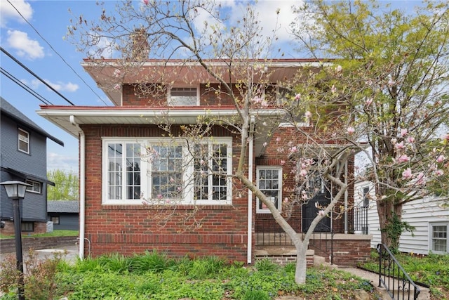 view of front of home with brick siding and a chimney