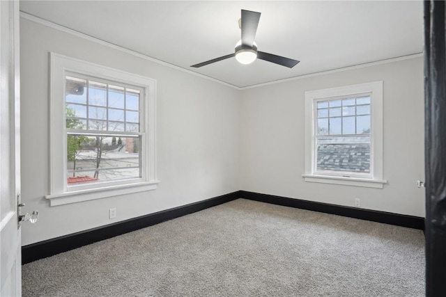 carpeted empty room with crown molding, baseboards, and ceiling fan