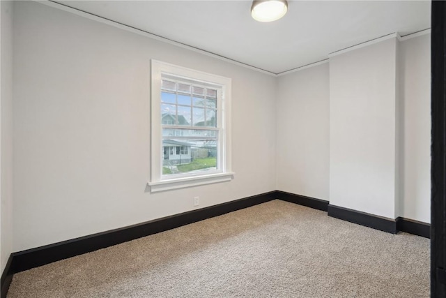 carpeted spare room with baseboards and ornamental molding