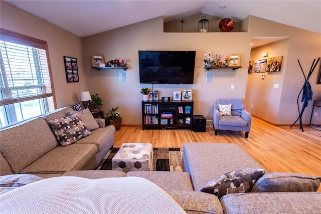 living room with baseboards, vaulted ceiling, and wood finished floors
