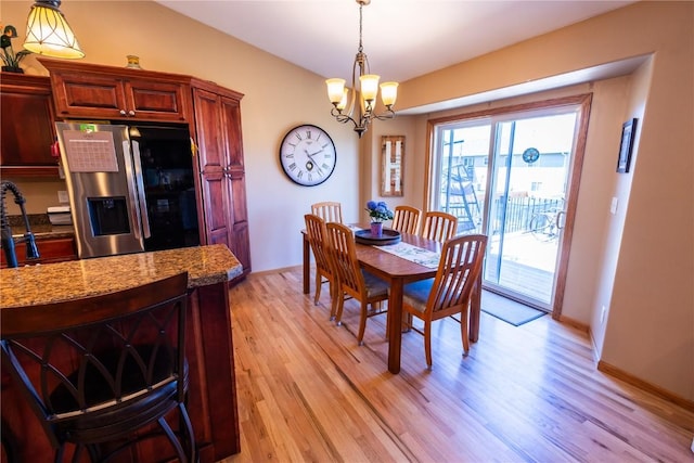 dining room featuring light wood-style flooring and a chandelier