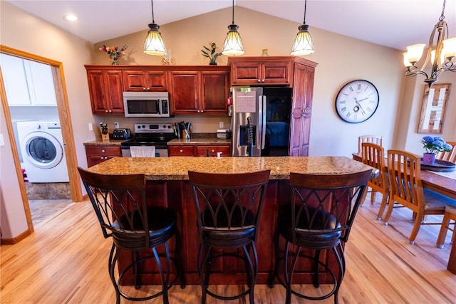 kitchen with washer / clothes dryer, light wood-type flooring, a chandelier, appliances with stainless steel finishes, and vaulted ceiling