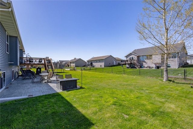 view of yard with a residential view, a wooden deck, a patio area, stairway, and a fenced backyard