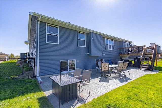 back of property with fence, a deck, a patio, a yard, and stairway