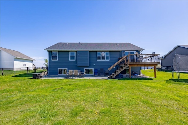 back of house featuring fence, a trampoline, stairs, a deck, and a patio