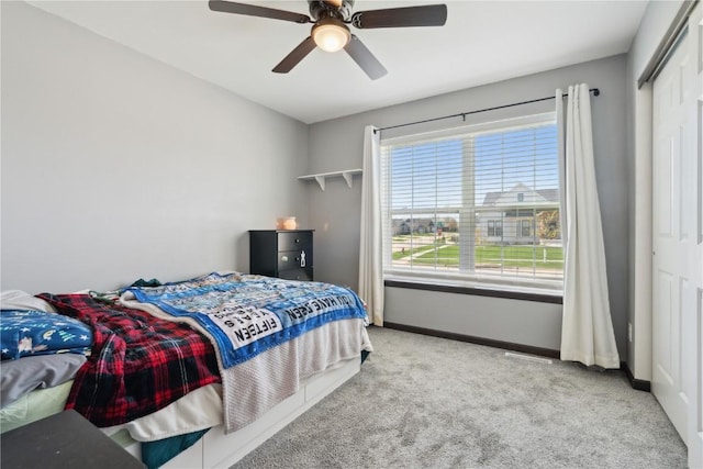 bedroom with carpet floors, baseboards, a ceiling fan, and a closet