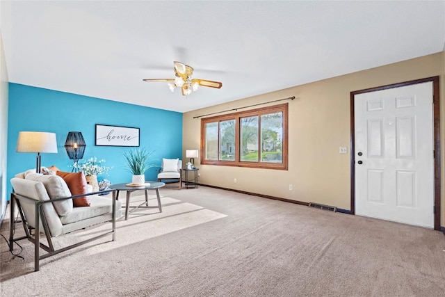 carpeted living room featuring baseboards, a ceiling fan, and visible vents