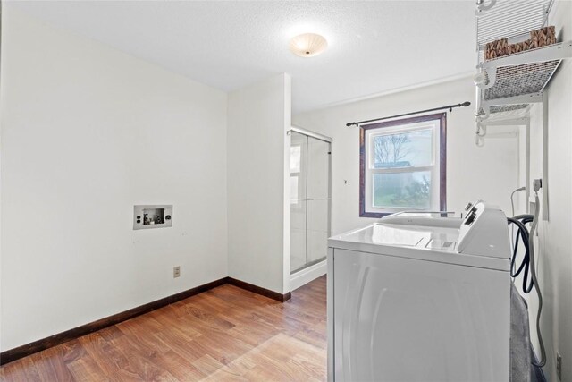 laundry area featuring washer / clothes dryer, baseboards, laundry area, and light wood finished floors