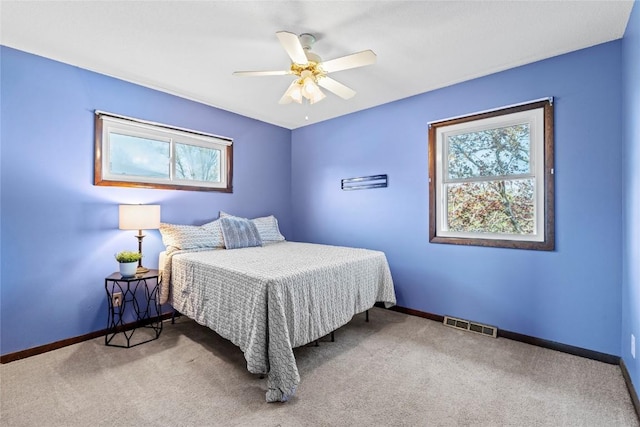 bedroom with carpet floors, baseboards, ceiling fan, and visible vents