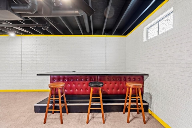 interior space with brick wall, a dry bar, and carpet