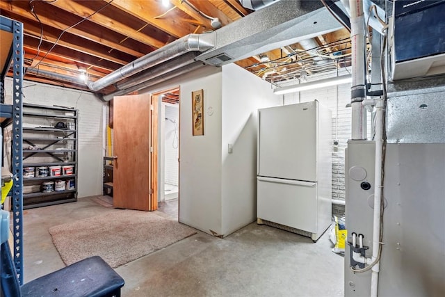 unfinished basement featuring heating unit, freestanding refrigerator, and visible vents