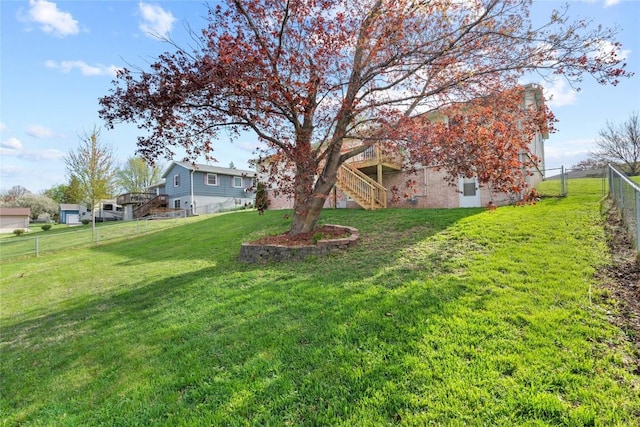 view of yard with stairway, a wooden deck, and a fenced backyard