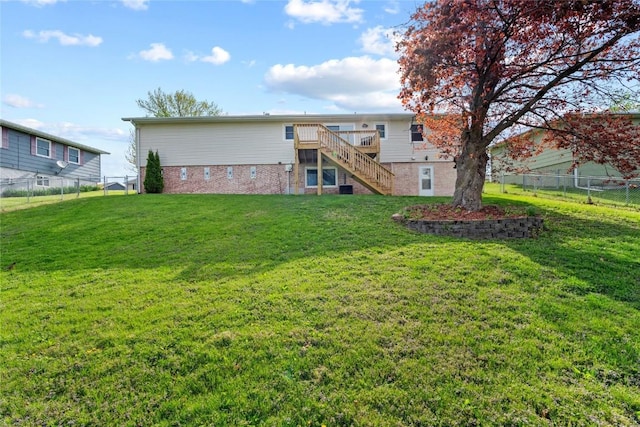 back of house featuring a fenced backyard, stairs, a yard, and a deck