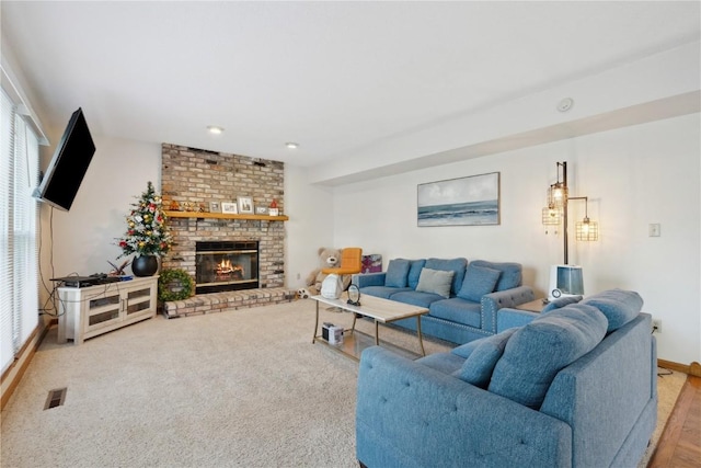 living room with baseboards, plenty of natural light, a brick fireplace, and visible vents