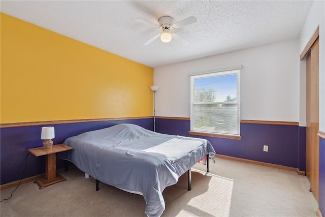 carpeted bedroom with baseboards, ceiling fan, and a closet