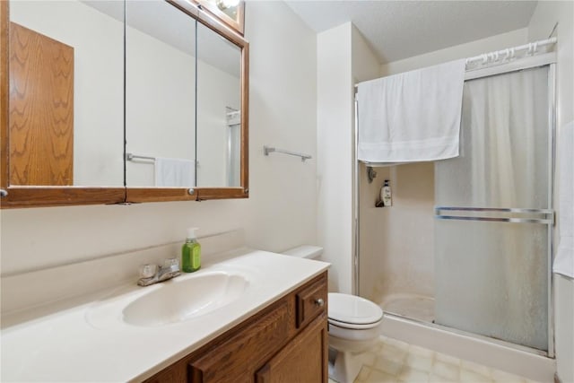 bathroom featuring vanity, a stall shower, and toilet