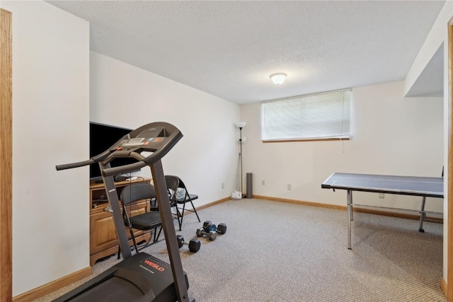 workout room with carpet flooring, a textured ceiling, and baseboards
