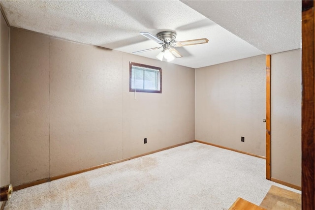 spare room with baseboards, a ceiling fan, carpet flooring, and a textured ceiling
