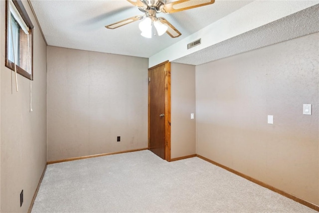 spare room featuring baseboards, carpet, a ceiling fan, and visible vents