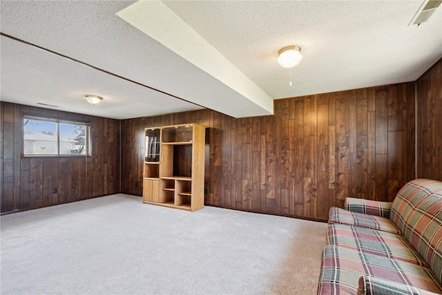 interior space featuring wooden walls, carpet floors, and a textured ceiling