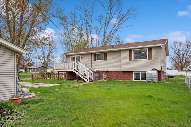 back of property featuring a lawn, a deck, central air condition unit, a fenced backyard, and stairs