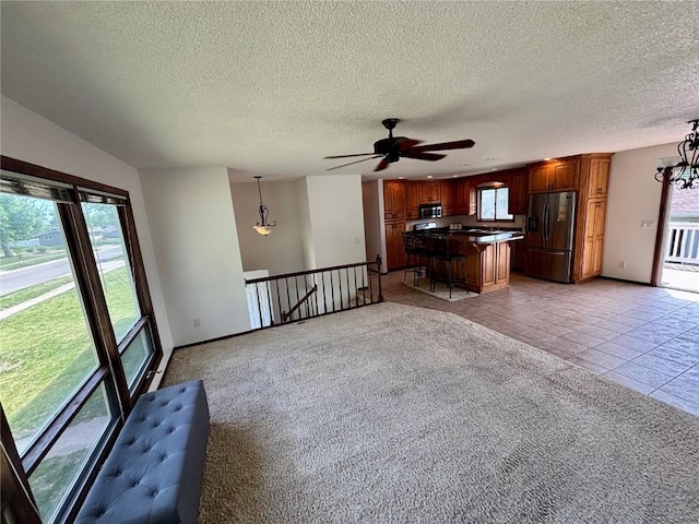 40 11th Ave, Hiawatha, IA 52233 - unfurnished living room with healthy amount of natural light, ceiling fan, a textured ceiling, and a chandelier