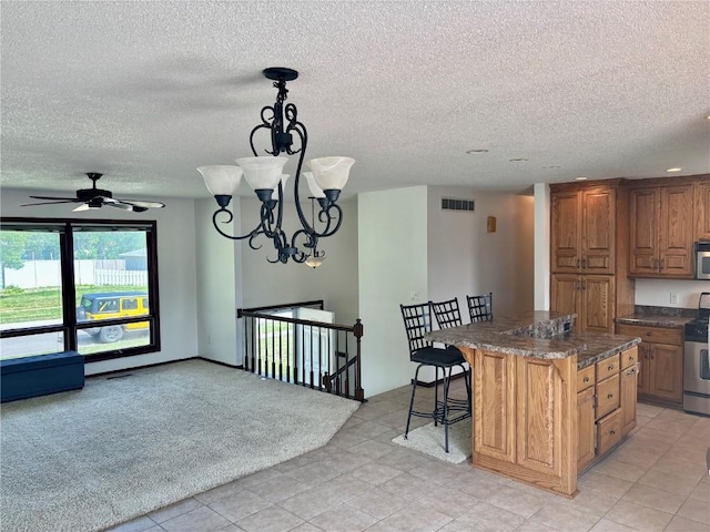 40 11th Ave, Hiawatha, IA 52233 - kitchen featuring a textured ceiling, stainless steel appliances, a center island, a breakfast bar, and a chandelier
