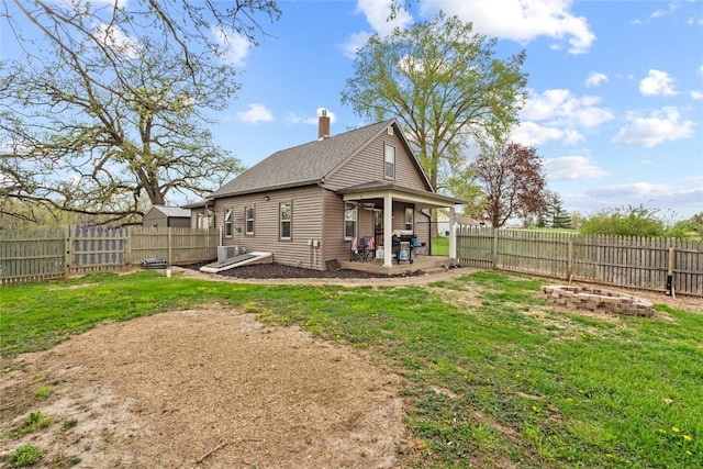 rear view of house featuring a lawn, a patio, and a fenced backyard