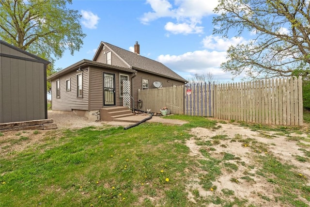 back of property featuring fence and a chimney