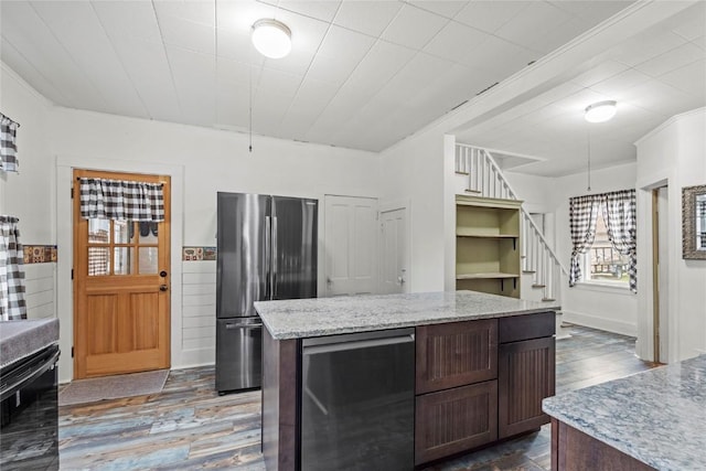 kitchen with light stone countertops, a center island, freestanding refrigerator, dark wood-type flooring, and refrigerator