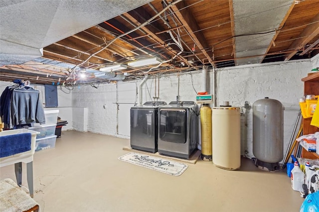unfinished basement featuring electric panel and washing machine and clothes dryer