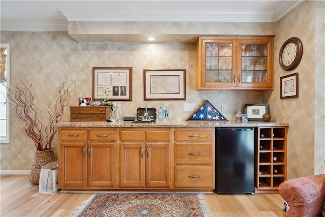 bar with crown molding, fridge, baseboards, and light wood-style floors