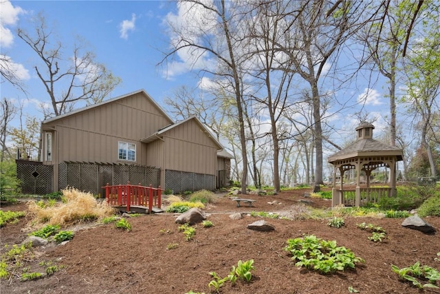 exterior space with board and batten siding and a gazebo