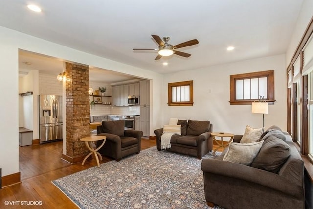 living area featuring recessed lighting, ceiling fan, dark wood-style flooring, and ornate columns