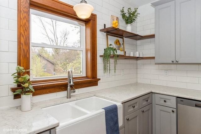 kitchen with stainless steel dishwasher, open shelves, a sink, and tasteful backsplash