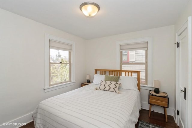 bedroom with baseboards and dark wood-style flooring