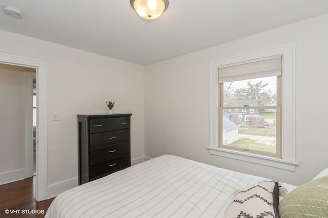 bedroom with baseboards and dark wood-style floors