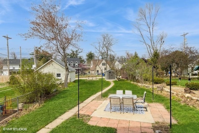 surrounding community featuring a shed, a patio area, a lawn, an outbuilding, and a residential view