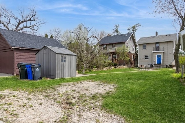 view of yard featuring a residential view, an outdoor structure, entry steps, and a storage unit