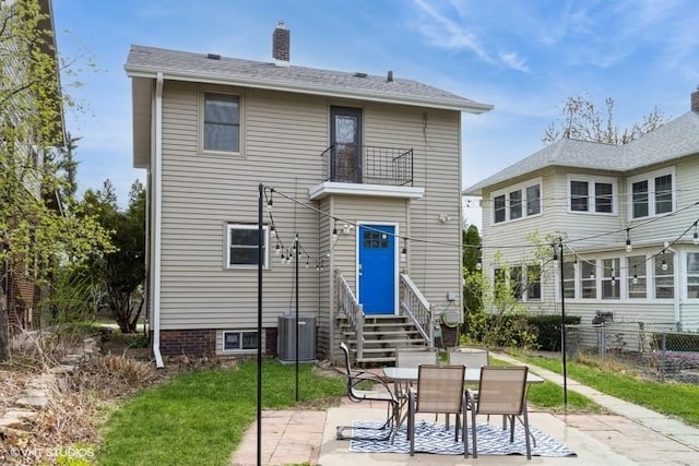 rear view of property with a chimney, central AC unit, a patio area, fence, and entry steps