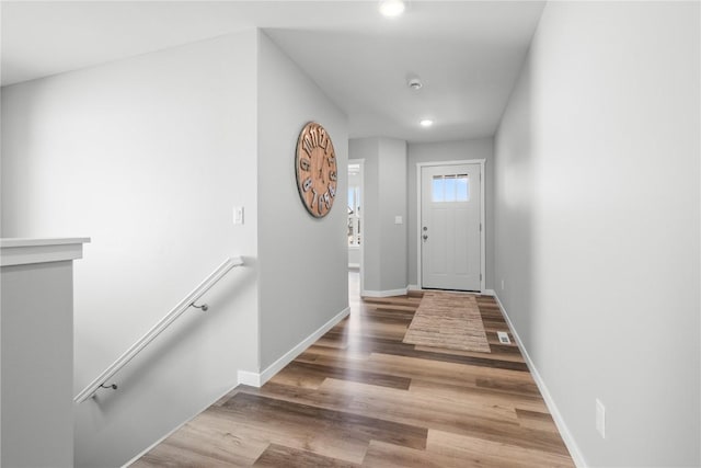 doorway with wood finished floors, recessed lighting, and baseboards