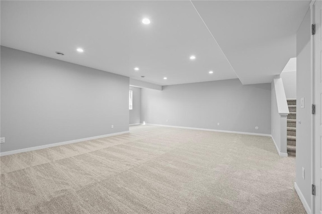 finished basement with recessed lighting, light carpet, stairs, and baseboards