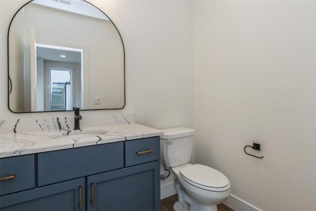938 Heron Pl, Iowa City, IA 52245 - bathroom with baseboards, vanity, toilet, and wood finished floors