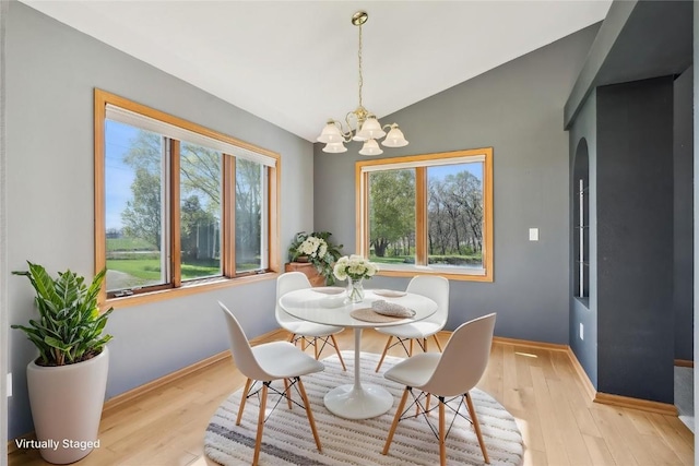 5141 25th Ave, Brandon, IA 52210 - dining space featuring baseboards, vaulted ceiling, an inviting chandelier, and light wood-type flooring