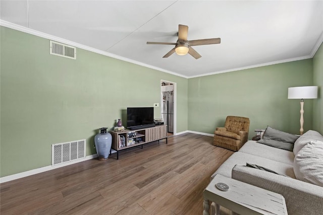 living area with visible vents, a ceiling fan, baseboards, and wood finished floors