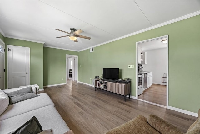 living room with ornamental molding, a ceiling fan, and dark wood-style floors