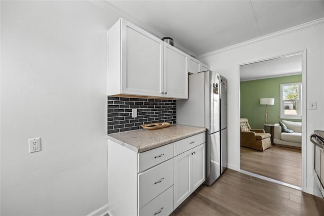 kitchen with light countertops, white cabinetry, crown molding, and dark wood finished floors