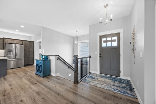 entrance foyer with an inviting chandelier, recessed lighting, light wood-style floors, and baseboards