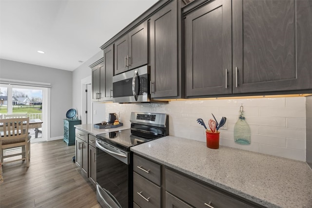 kitchen with recessed lighting, appliances with stainless steel finishes, decorative backsplash, and wood finished floors