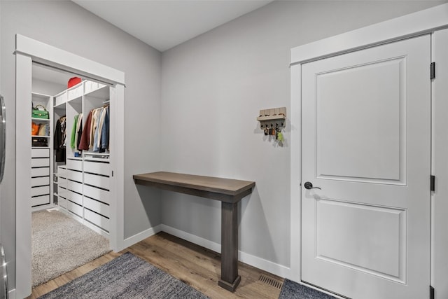 doorway featuring baseboards and wood finished floors